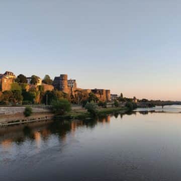 Vue sur les renparts d'Angers depuis le fleuve à l'aube.