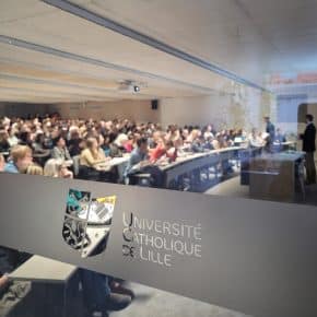 Vue d'un amphithéâtre plein par une fenêtre avec une vitrophanie Université Catholique de Lille